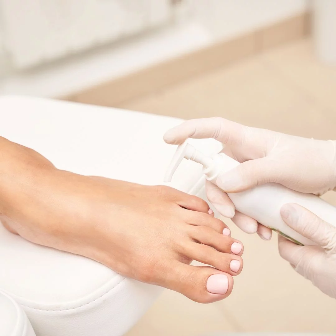 Nahaufnahme einer professionellen Pediküre-Behandlung mit rosa lackierten Zehennägeln.
